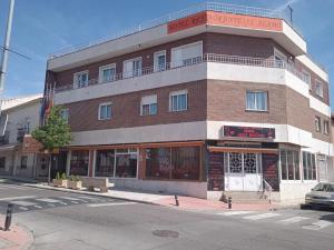 a large brick building on a street corner at H El ALAMO MADRID in El Álamo