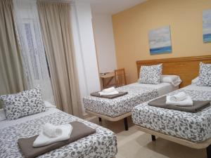 ein Hotelzimmer mit 2 Betten und einem Tisch in der Unterkunft H El ALAMO MADRID in El Álamo