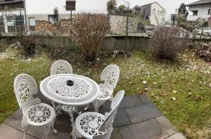 einen weißen Tisch und Stühle auf einer Terrasse in der Unterkunft Ferienwohnung Hochfelln in Prien am Chiemsee