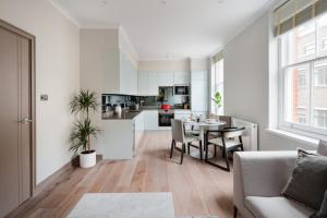 uma cozinha e sala de estar com mesa e cadeiras em Cosy Two Bedroom Apartment in Holborn em Londres