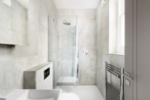 uma casa de banho com um chuveiro, um WC e um lavatório. em Cosy Two Bedroom Apartment in Holborn em Londres
