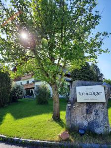 a sign sitting on a rock next to a tree at Pension Kreuzinger, 5310 Tiefgraben in Mondsee