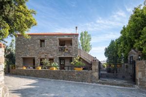 a stone house with a gate in front of it at Chorostasi Guest House in Parthenonas