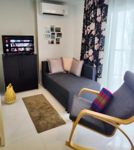 a living room with a couch and a tv at Mantra Holiday Home in Mae Pim