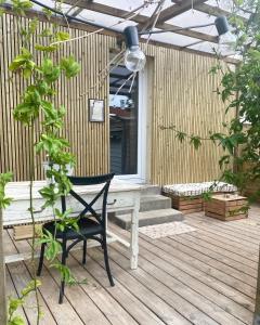 une terrasse en bois avec un banc et une plante dans l'établissement Adorables studios - emplacement idéal, à Saint-Gilles-Croix-de-Vie