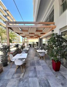 una fila de mesas y sillas en el exterior de un edificio en Elite Hotel, en Rodas