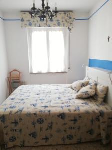 Schlafzimmer mit einem Bett mit einer blauen und weißen Bettdecke in der Unterkunft Al mare con vista codice CITRA 009049-LT-0787 in Pietra Ligure