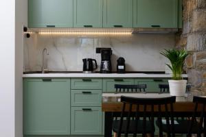 a kitchen with green cabinets and a table with chairs at La Terra Petra in Skala Rachoniou