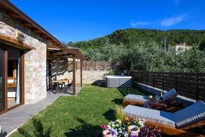 a garden with a patio with a table and chairs at La Terra Petra in Skala Rachoniou
