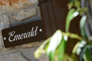 a sign on a brick wall with the word emerald at La Terra Petra in Skala Rachoniou