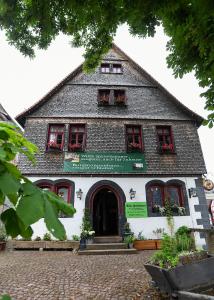 - un grand bâtiment avec des fenêtres rouges et une porte dans l'établissement Burgmannenhaus, à Steinau an der Straße