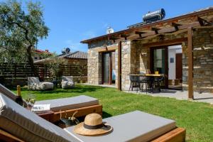 a backyard with a stone house with a patio at La Terra Petra in Skala Rachoniou
