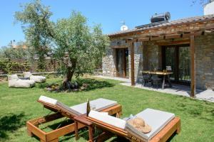 a garden with a picnic table and a stone house at La Terra Petra in Skala Rachoniou