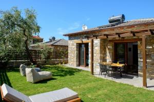 a patio with a table and chairs in a yard at La Terra Petra in Skala Rachoniou