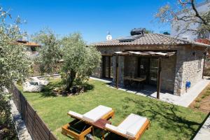 a garden with a patio and a house at La Terra Petra in Skala Rachoniou