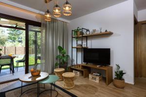 a living room with a television and a table and chairs at La Terra Petra in Skala Rachoniou