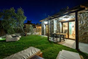a backyard at night with a table and chairs at La Terra Petra in Skala Rachoniou