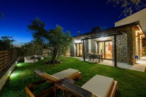 a garden with a stone house at night at La Terra Petra in Skala Rachoniou
