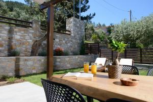 a wooden table with books and drinks on a patio at La Terra Petra in Skala Rachoniou