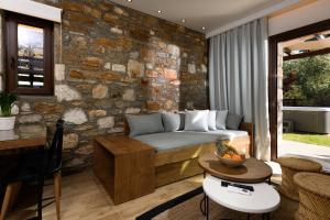 a living room with a couch and a stone wall at La Terra Petra in Skala Rachoniou