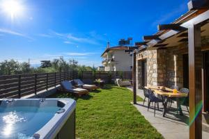 a backyard with a hot tub and a table and chairs at La Terra Petra in Skala Rachoniou