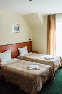 Dos camas en una habitación de hotel con toallas. en Dionis Hotel en Varna