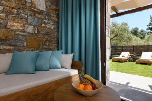 a living room with a couch and a bowl of fruit on a table at La Terra Petra in Skala Rachoniou