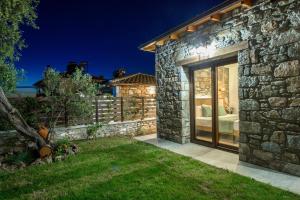 a stone house with a sliding glass door at La Terra Petra in Skala Rachoniou