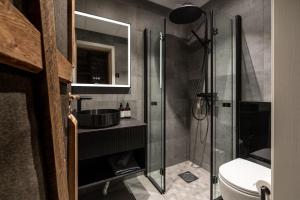 ein Bad mit einer Dusche und einem Waschbecken in der Unterkunft Basecamp Hotel in Longyearbyen