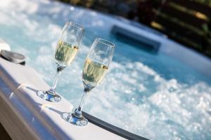 two glasses of wine sitting next to a swimming pool at La Terra Petra in Skala Rachoniou