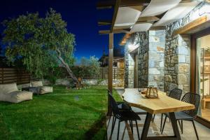 a patio with a table and chairs in a yard at La Terra Petra in Skala Rachoniou