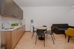 a kitchen with a table and chairs and a couch at Trsteno Beach Apartments in Budva