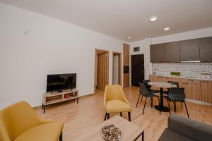 a living room with a couch and a table with chairs at Trsteno Beach Apartments in Budva