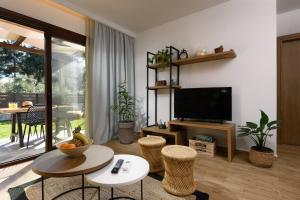 a living room with a television and a table and chairs at La Terra Petra in Skala Rachoniou