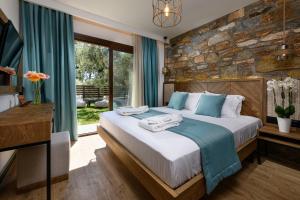 a bedroom with a large bed and a stone wall at La Terra Petra in Skala Rachoniou