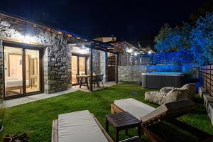 a backyard with a stone house at night at La Terra Petra in Skala Rachoniou