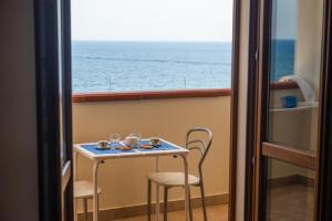 - une table avec des chaises et une vue sur l'océan dans l'établissement B&B Sulmare, à Marettimo