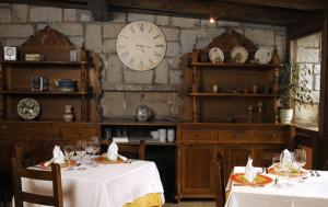 ein Esszimmer mit zwei Tischen und einer Uhr an der Wand in der Unterkunft Hotel Pirineos in Castejón de Sos