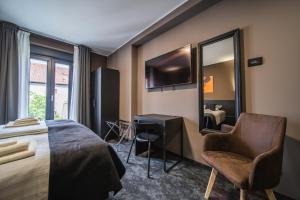 a bedroom with a bed and a chair and a mirror at Rustica Rooms in Čakovec