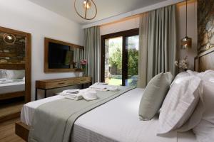 a bedroom with a large white bed and a window at La Terra Petra in Skala Rachoniou