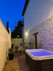 uma banheira de hidromassagem num quintal com um pátio em l'atelier spa em Bayeux