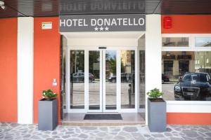 une porte d'entrée avec deux plantes en pot devant l'hôtel dans l'établissement Hotel Donatello, à Modène