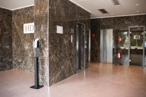 un vestíbulo con dos ascensores y un teléfono en la pared en Hotel Donatello, en Módena