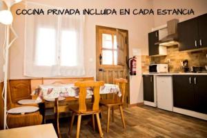 een keuken met een tafel en stoelen in een kamer bij Apartamentos turísticos LAS CARBALLEDAS in Rabanal del Camino