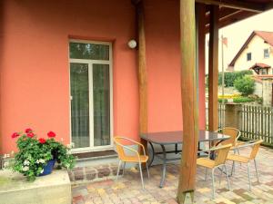 eine Terrasse mit einem Tisch, Stühlen und einem Fenster in der Unterkunft Heiterer Blick am Malerweg Pirna in Pirna