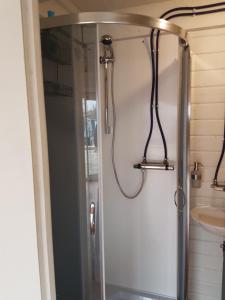 um chuveiro com uma porta de vidro na casa de banho em Großes gemütliches Hausboot in Berlin em Berlim