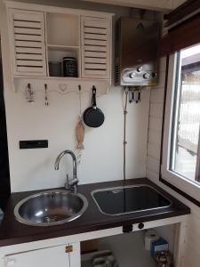 a small kitchen with a sink and a stove at Großes gemütliches Hausboot in Berlin in Berlin