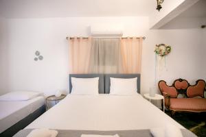 a bedroom with a bed and two chairs at Mylos villa Mani in Pírgos