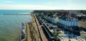 - une vue aérienne sur une plage avec une jetée dans l'établissement Beau Rivage Hôtel-Restaurant, à Luc-sur-Mer