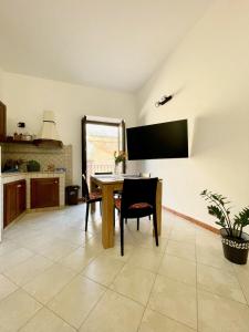 a kitchen with a table and a tv on the wall at Civico 22 in Trapani